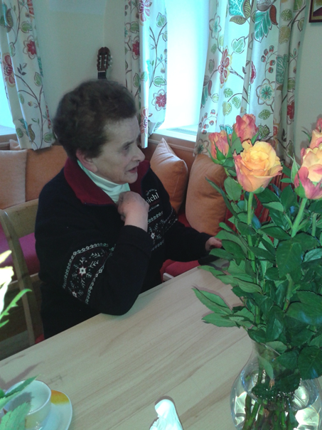 eine Person, die an einem Tisch mit einer Vase mit Blumen sitzt